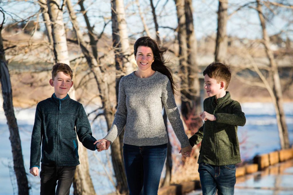 mom and two boys walking in the park