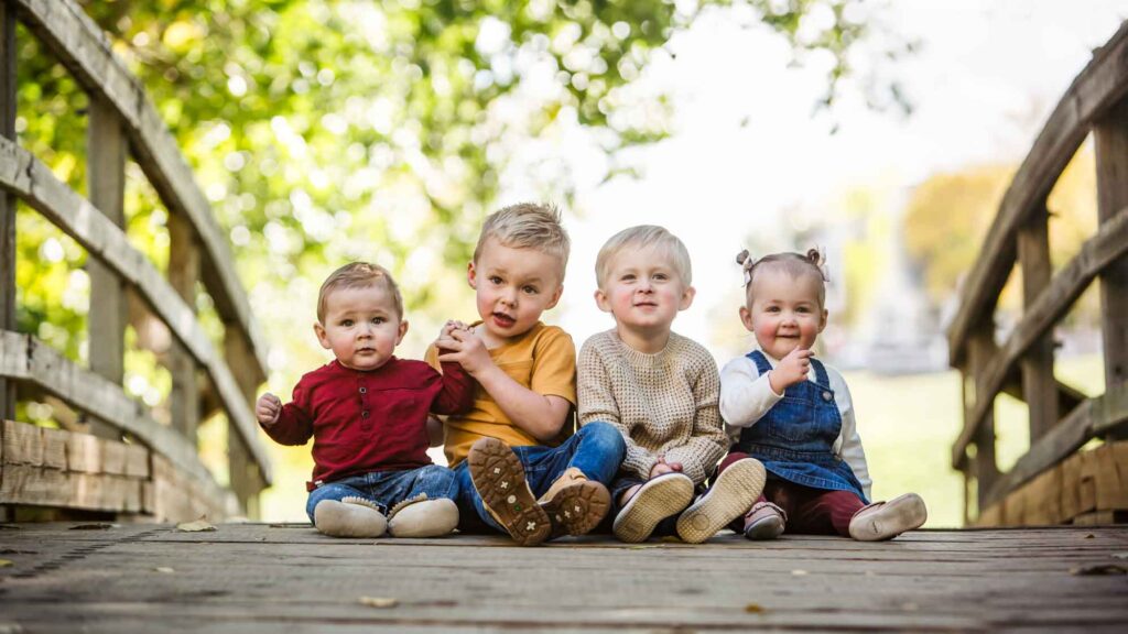 toddlers sitting on a bridge