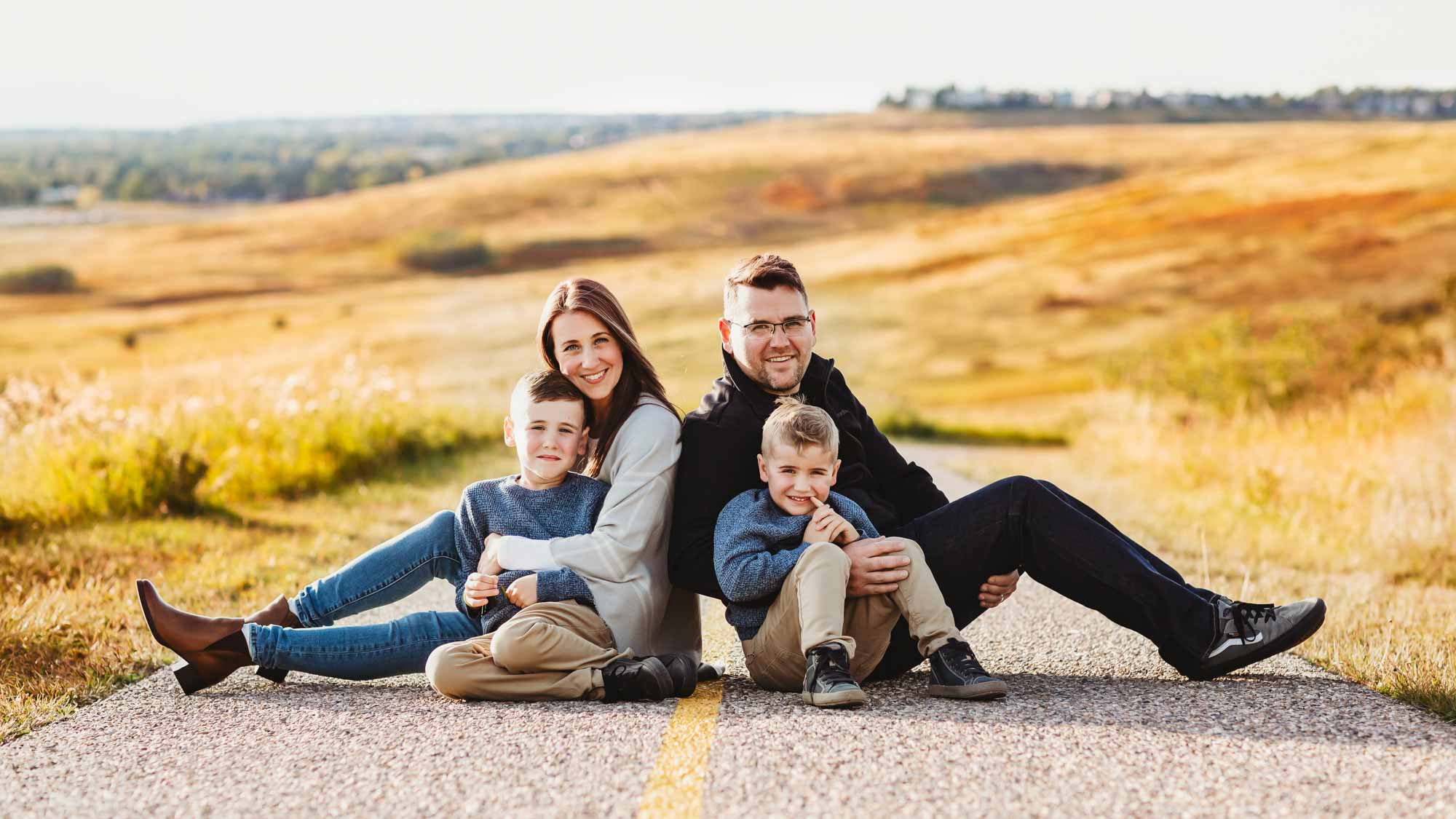 family of four sitting on the pathway